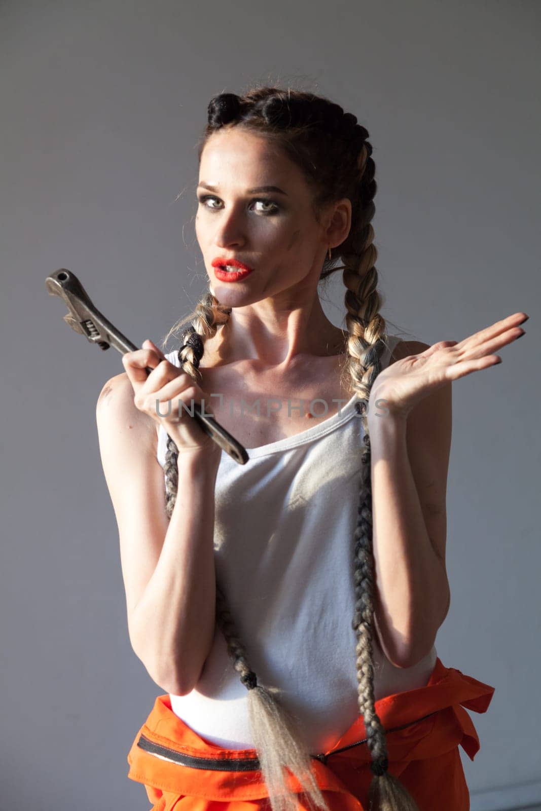 Portrait of a beautiful fashionable woman mechanic with two braids