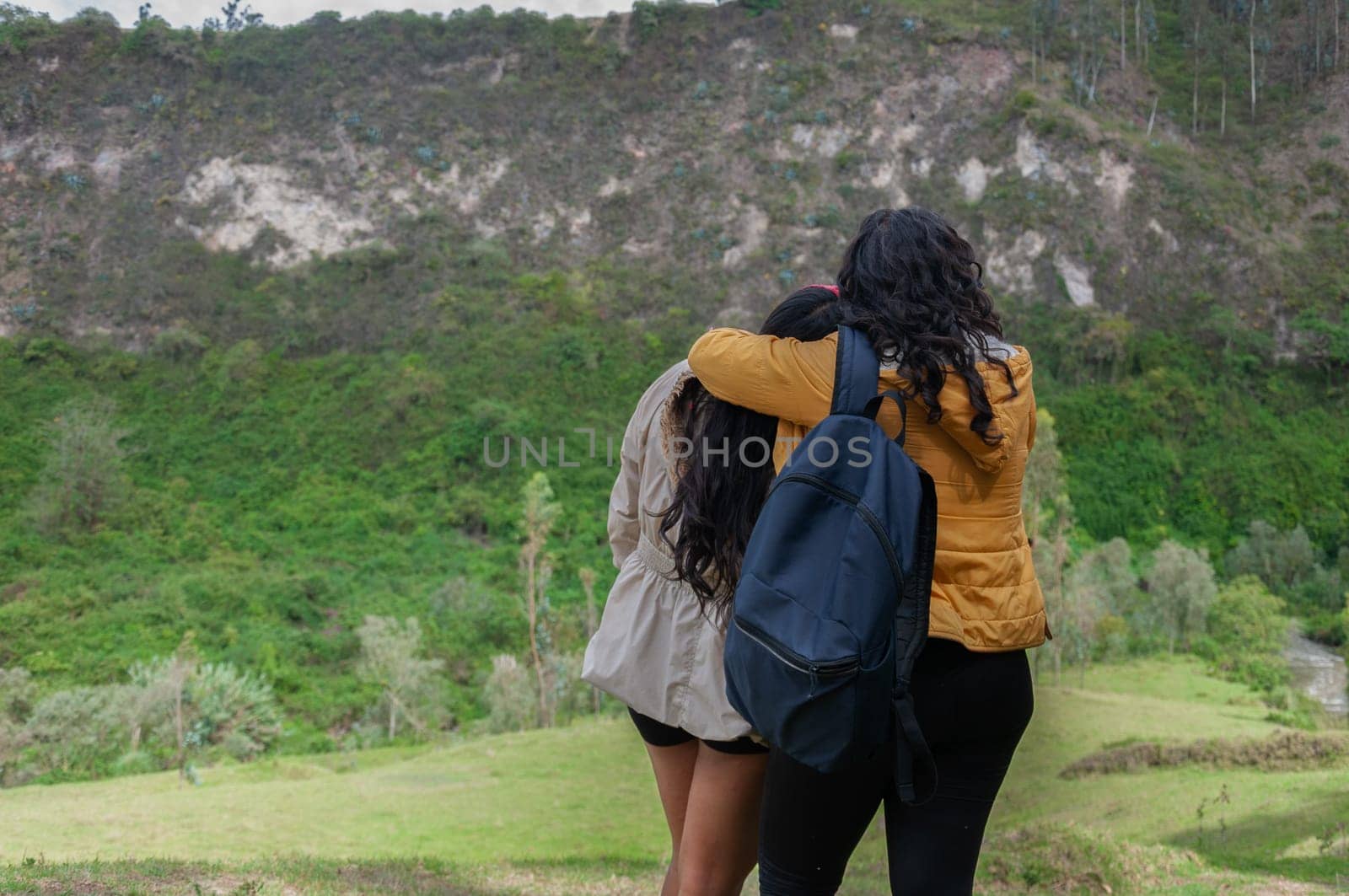 two girls hugging each other, demonstrating the love they feel for each other while breathing the pure mountain air by Raulmartin