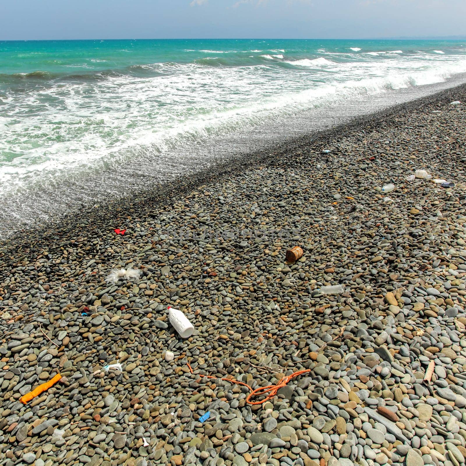 Mostly plastic rubbish on rough pebbles beach. Ocean and sea littering concept by Ivanko