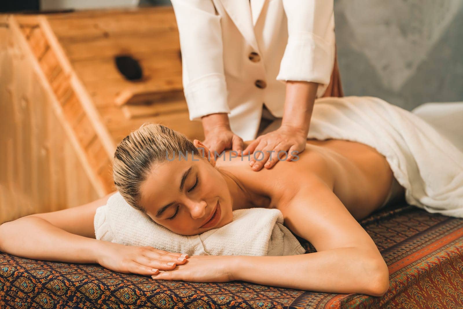 Beautiful woman having back massage in front of sauna cabinet. Tranquility. by biancoblue