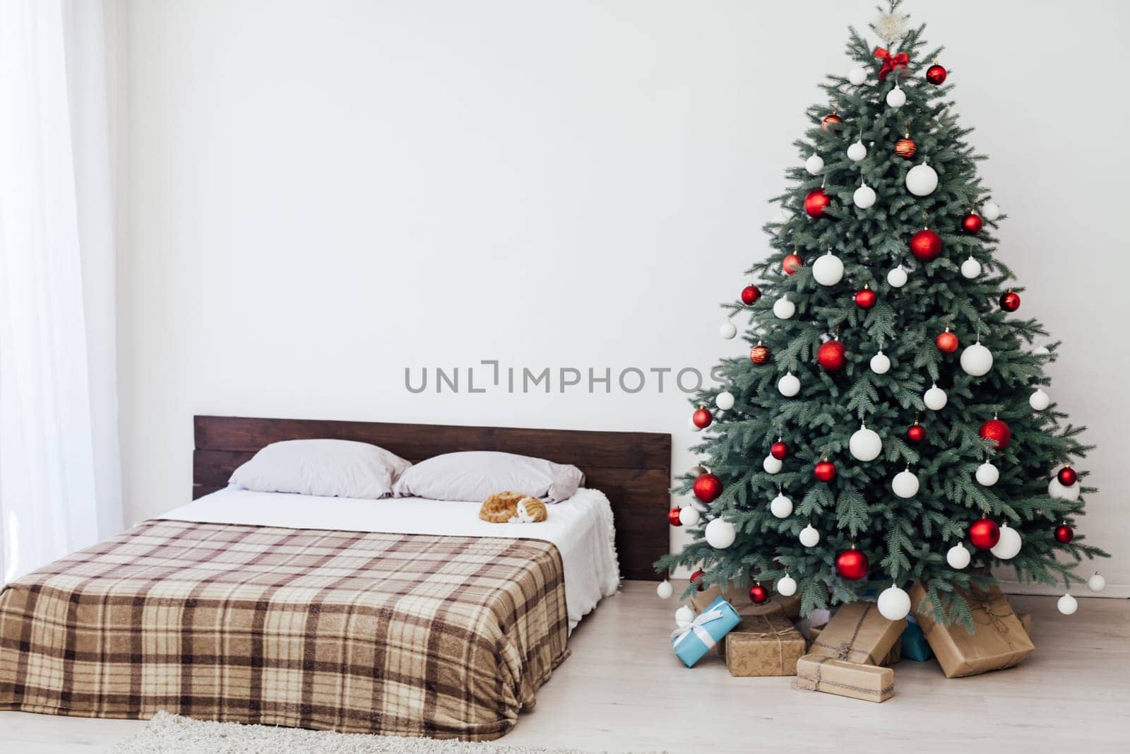 New year bedroom decor with Christmas tree bed with gifts and garlands interior by Simakov