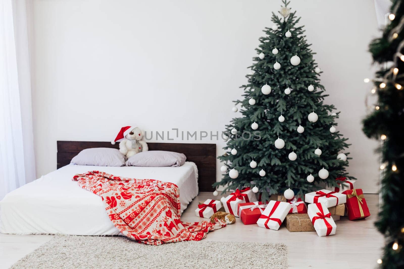 New year bedroom decor with Christmas tree bed with gifts and garlands interior by Simakov