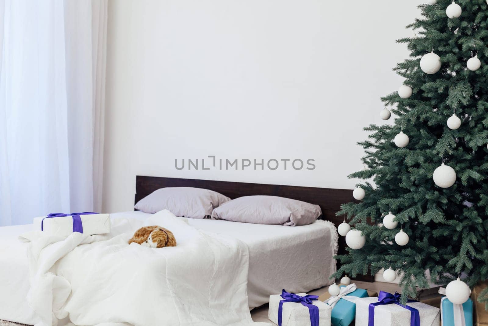 New year bedroom decor with Christmas tree bed with gifts and garlands