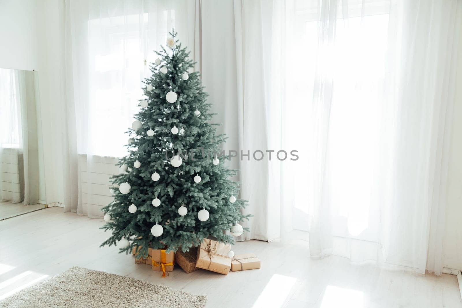 New Year's decoration Christmas tree with gifts and garlands interior by Simakov