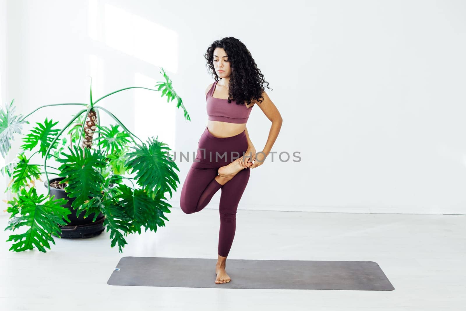 woman brunette engaged in yoga fitness asana body flexibility by Simakov