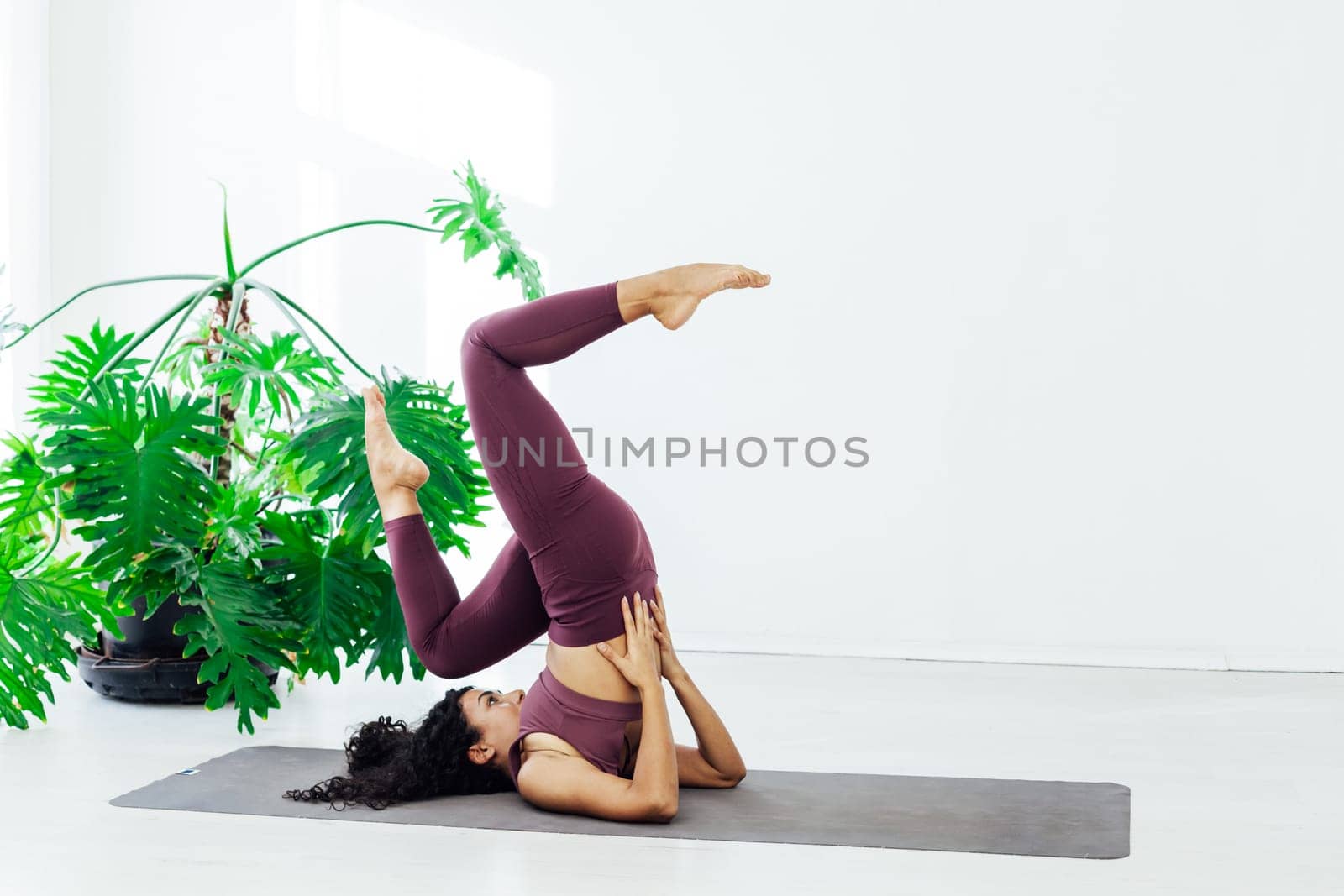 Sportswoman brunette engaged in yoga fitness asana body flexibility