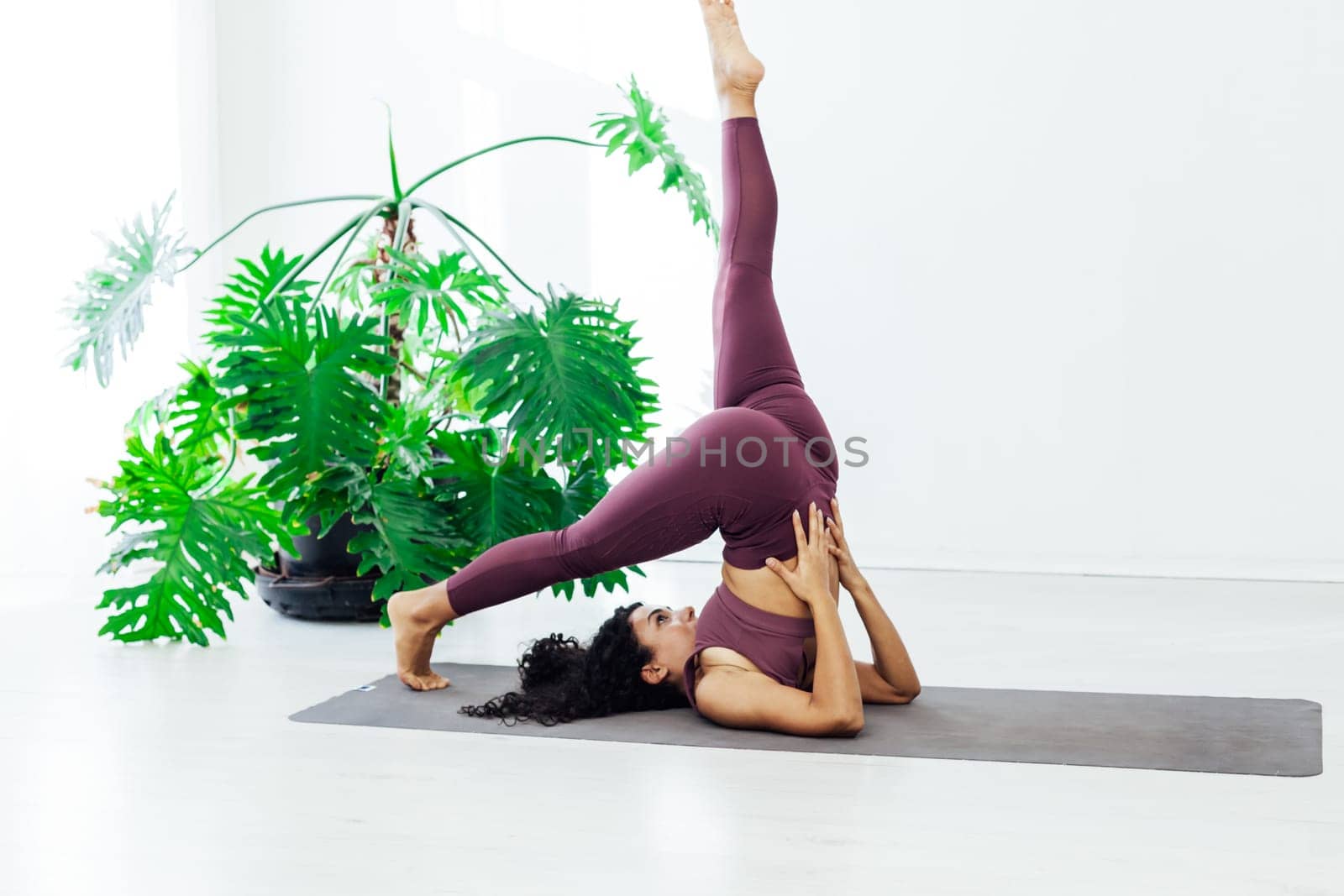 woman brunette engaged in yoga fitness asana body flexibility by Simakov