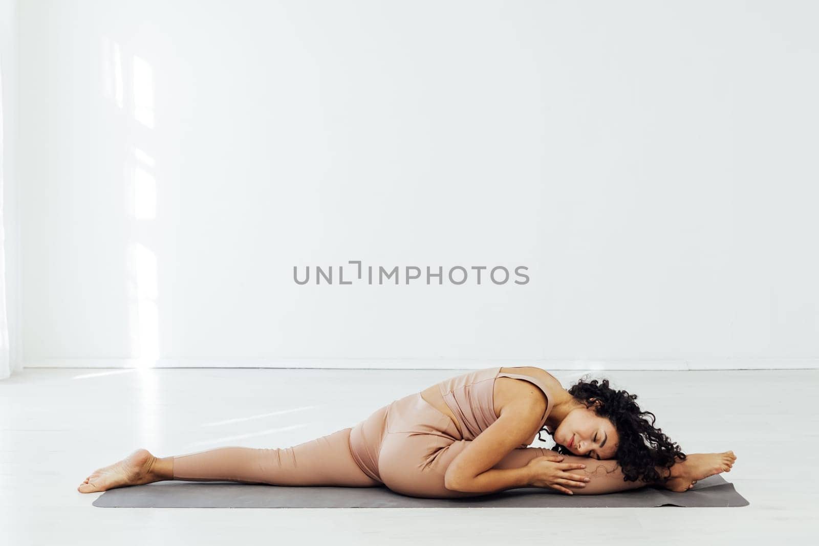 Beautiful brunette woman engaged in yoga asana flexibility body
