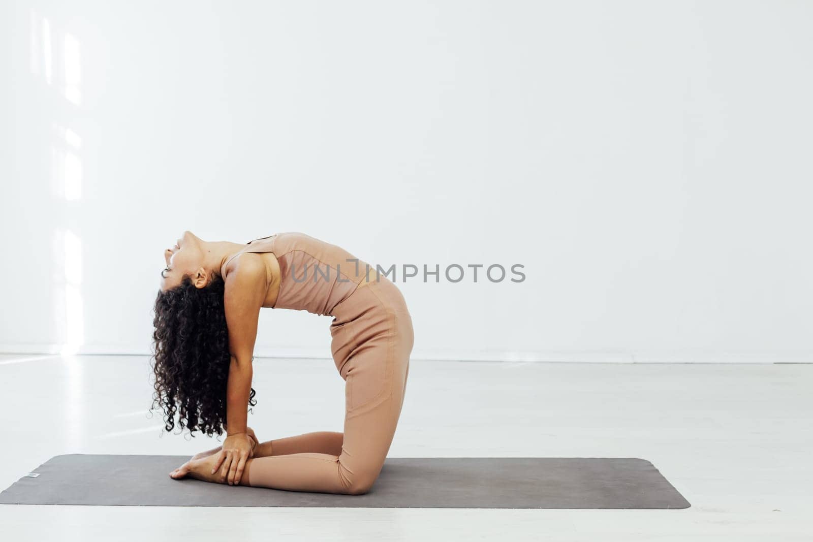Beautiful brunette woman engaged in yoga fitness asana flexibility body by Simakov