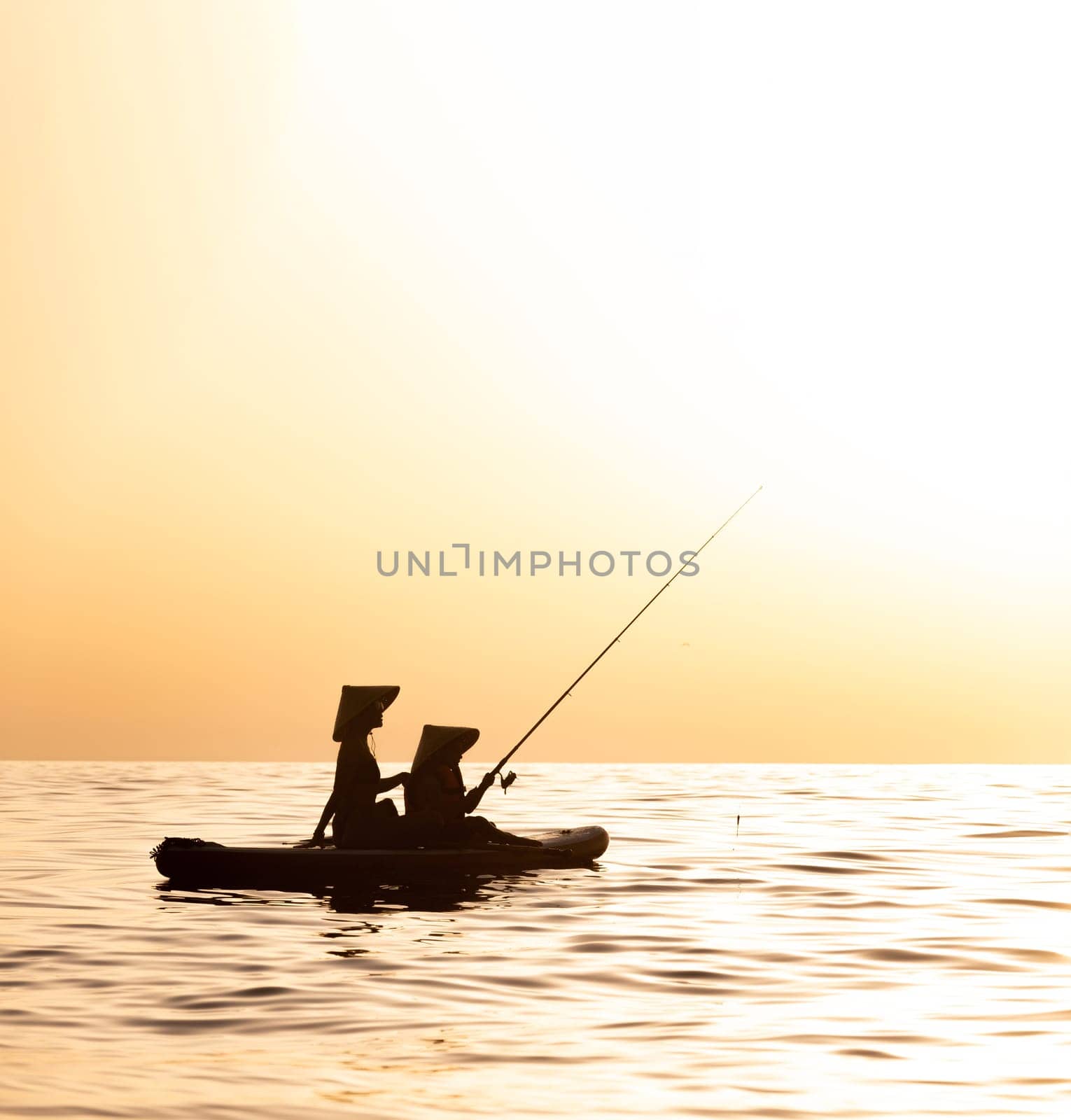 a woman with a child on a sup board in the sea swim against the background of a beautiful sunset, Standup paddleboarding by Rotozey