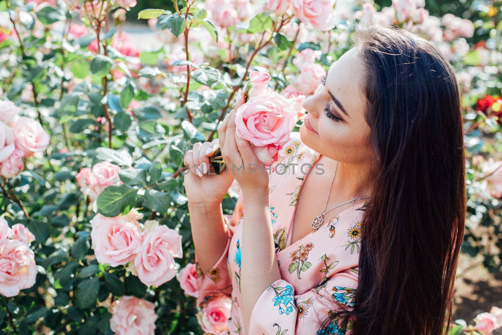 woman in a dress with flowers walks in the park alone