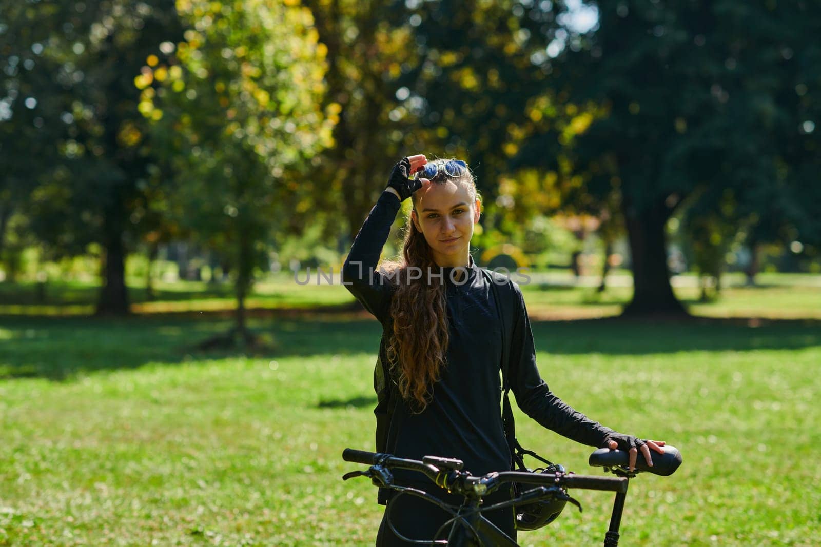 In the radiant embrace of a sunny day, a joyous girl, adorned in professional cycling gear, finds pure bliss and vitality as she cruises through the park on her bicycle, her infectious laughter echoing the carefree harmony of the moment by dotshock