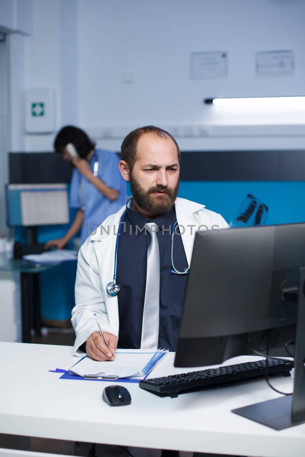 Man examining a chest scan of a patient by DCStudio