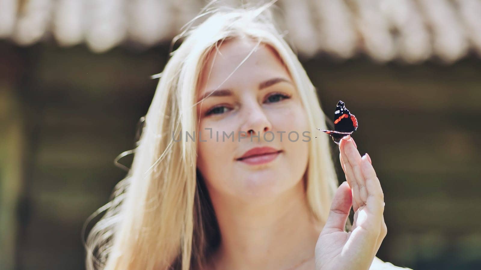 Young blonde girl with a butterfly on a summer afternoon