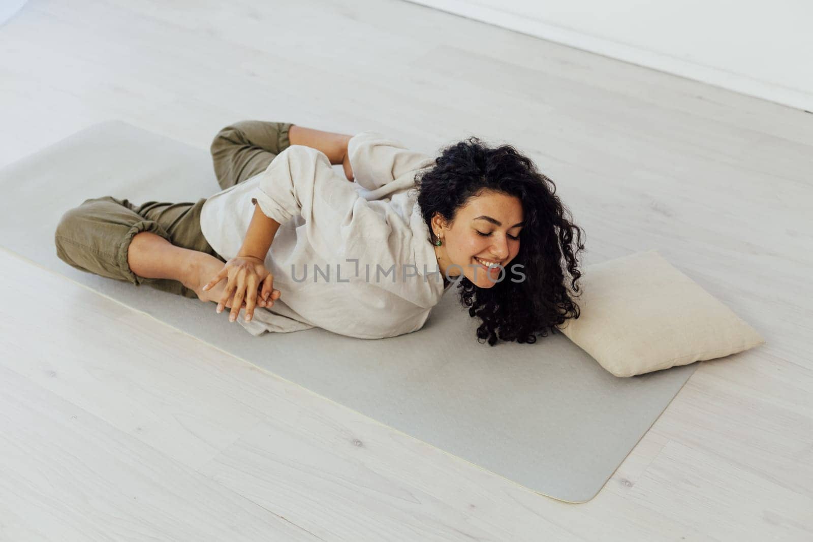 Brunette woman engaged in yoga asana gymnastics flexibility body by Simakov