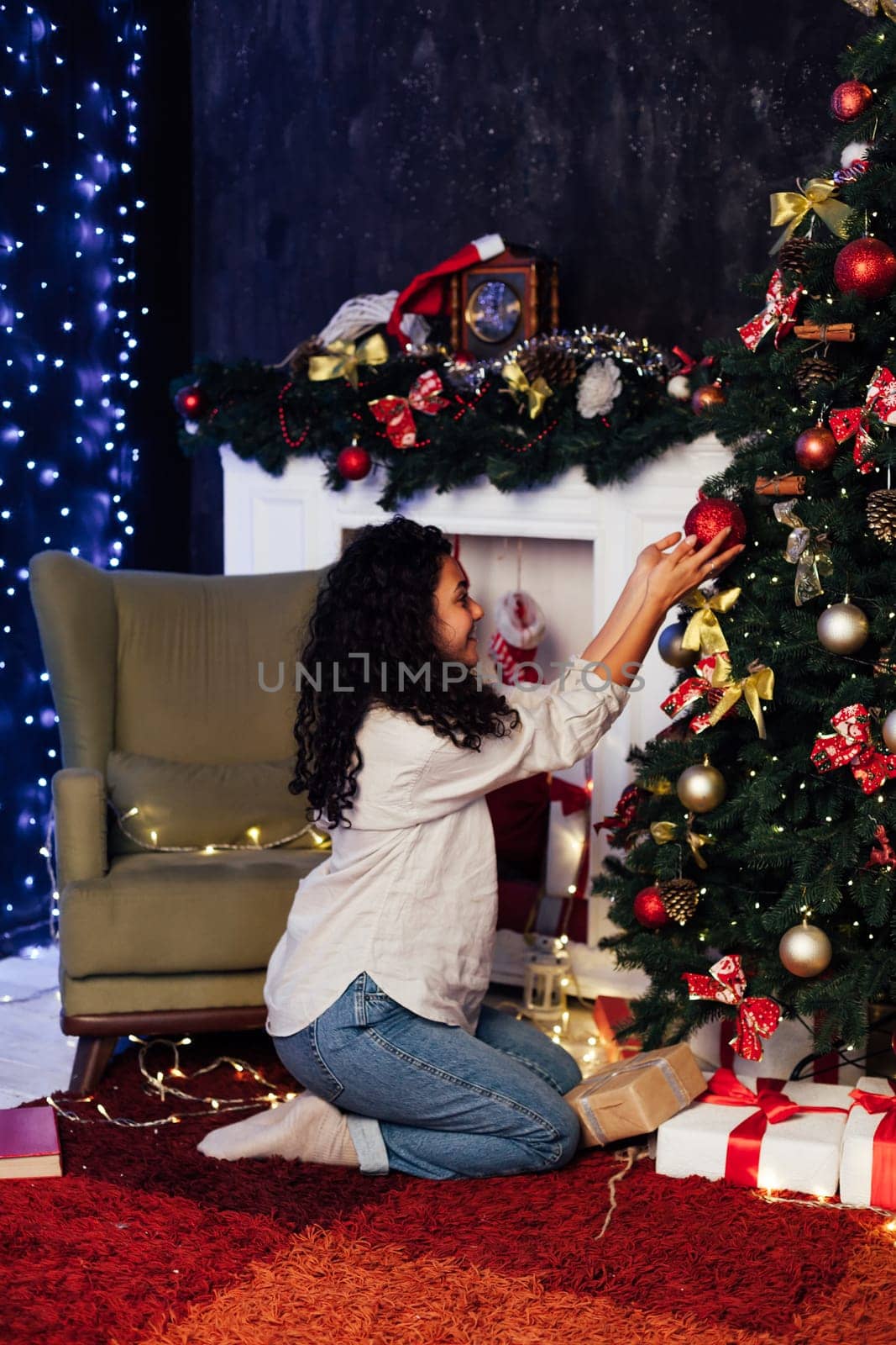 Beautiful woman decorates Christmas tree opens gifts for the new year