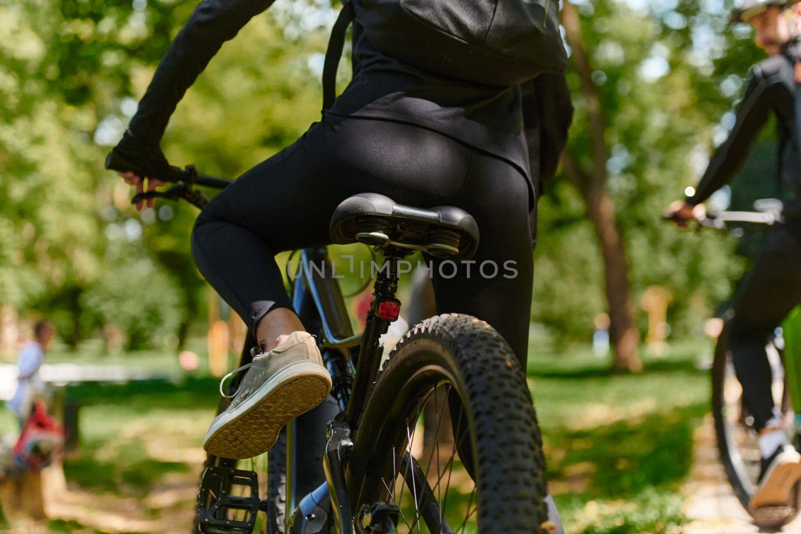 A sports bicycle races through the park, its components in focused motion spinning wheels, agile pedals, and sleek handlebars creating a dynamic spectacle of athleticism and speed against the backdrop of lush greenery.