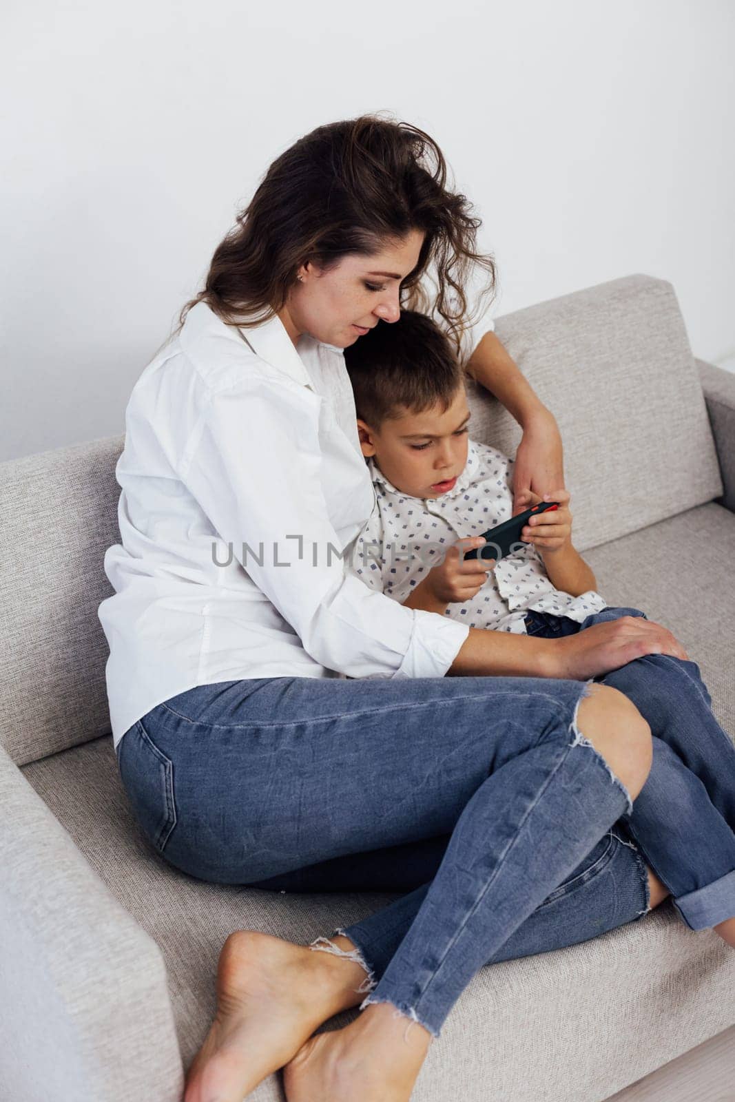 Mom and son watch smartphone games online by Simakov