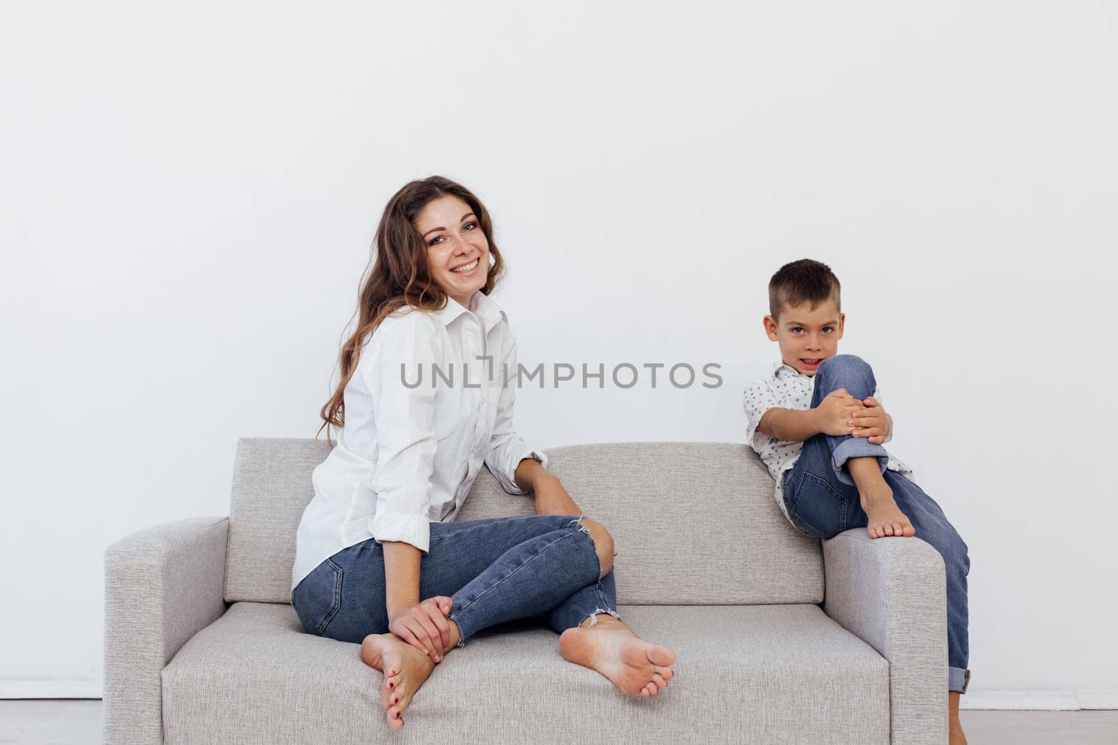 Mom and son sit on the sofa at home in a room