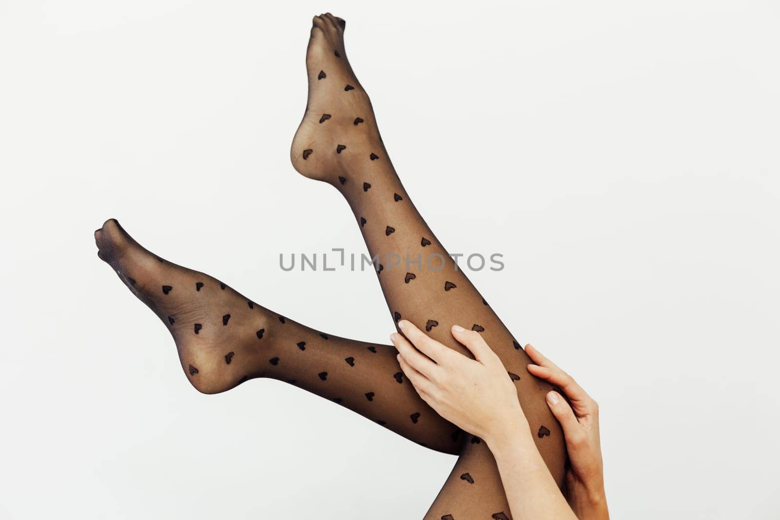 slender women's legs in black tights on a white background