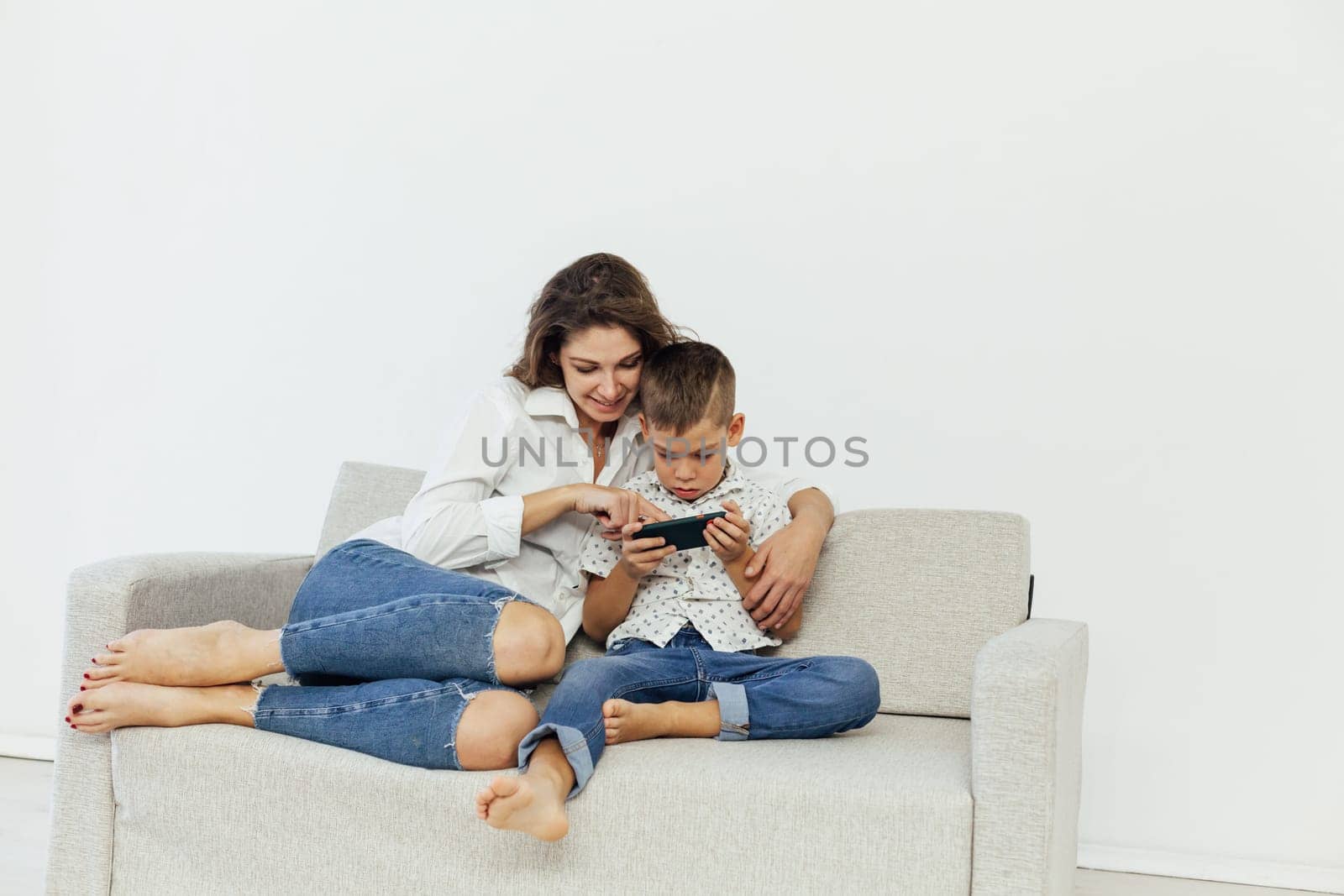 Mom and son watch smartphone games online by Simakov