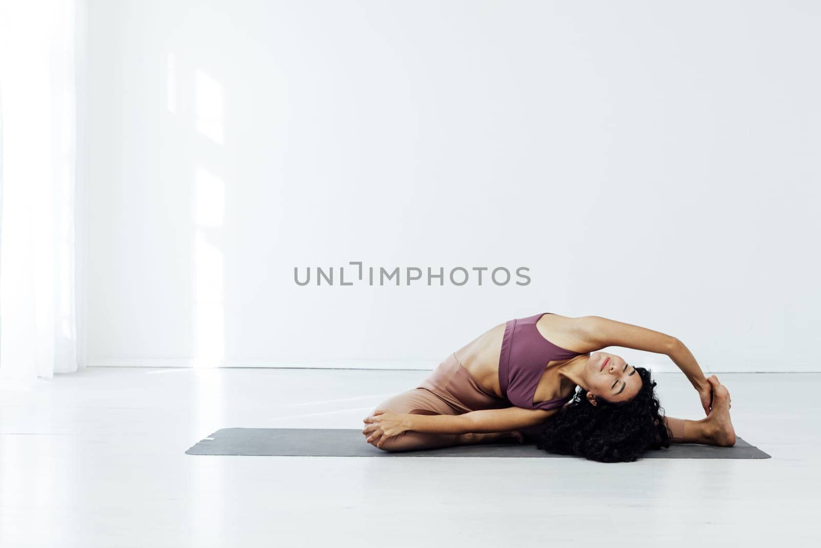 Beautiful woman yoga asana engaged in fitness sport gym by Simakov