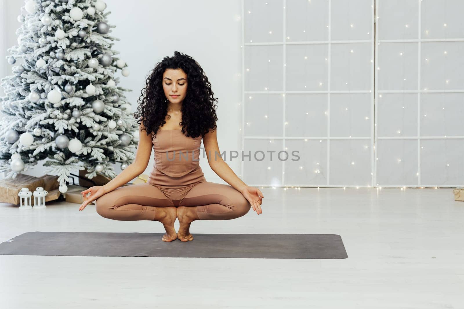 Woman yoga asana gymnastics at Christmas tree New Year by Simakov