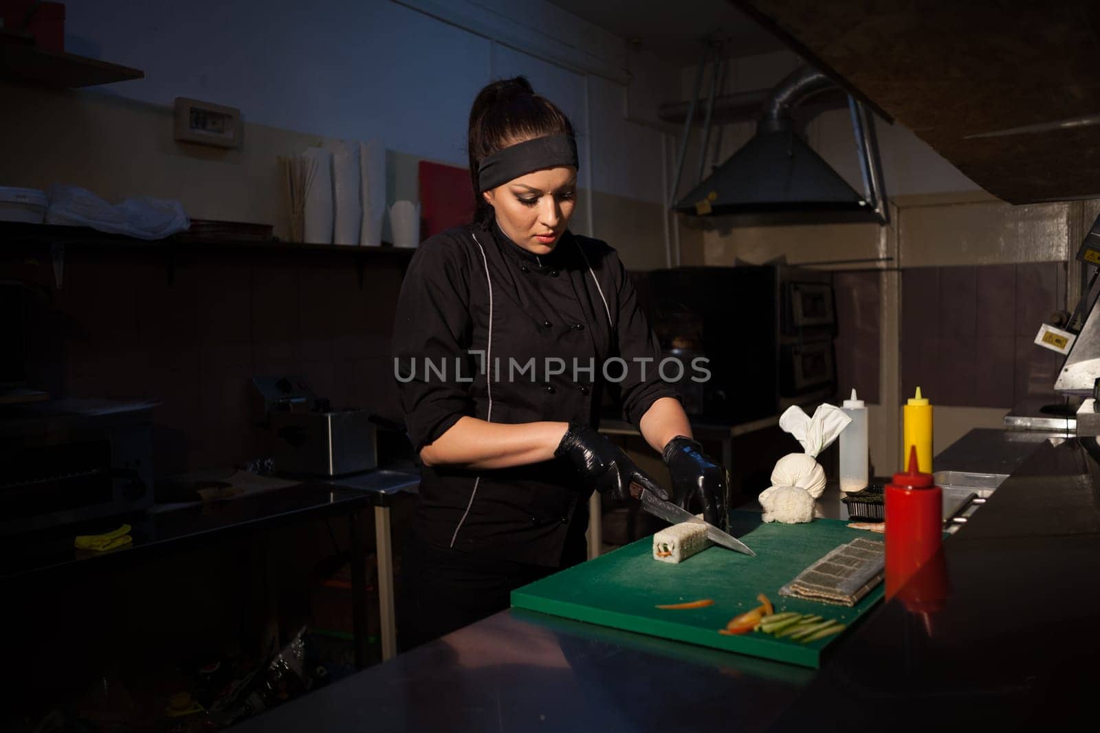 girl sushi chef prepares food in the kitchen at restaurant 1