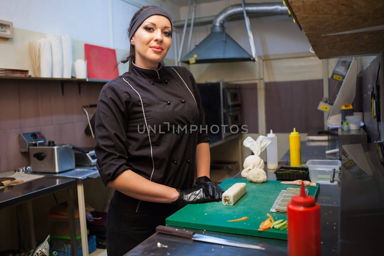 girl sushi chef prepares food in the kitchen at restaurant 1