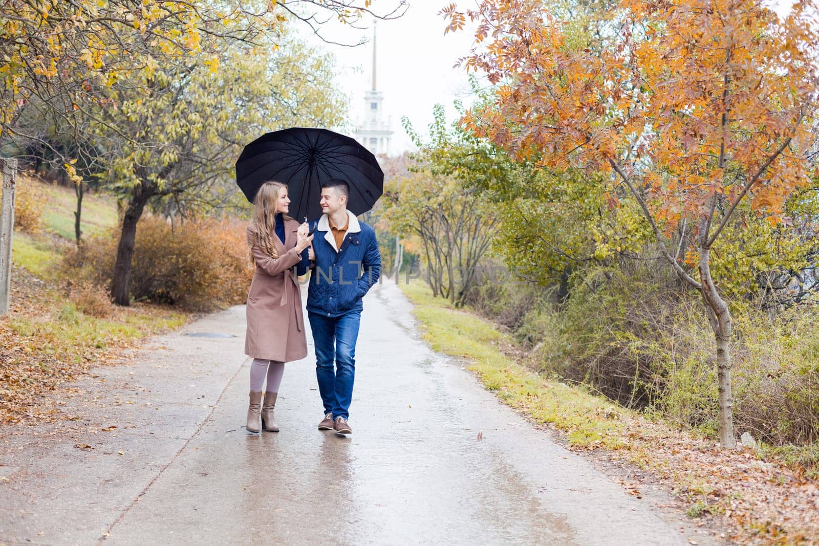 a guy with a girl go under umbrella rain good mood