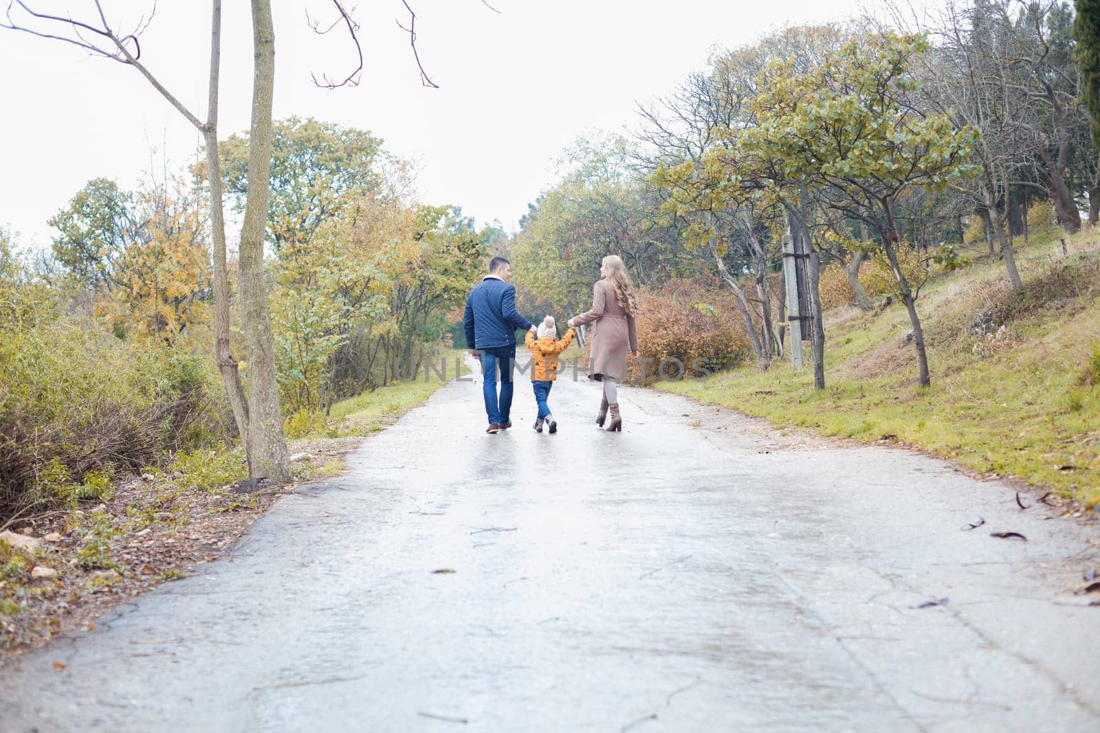 a family with a son go on doroke in the rain