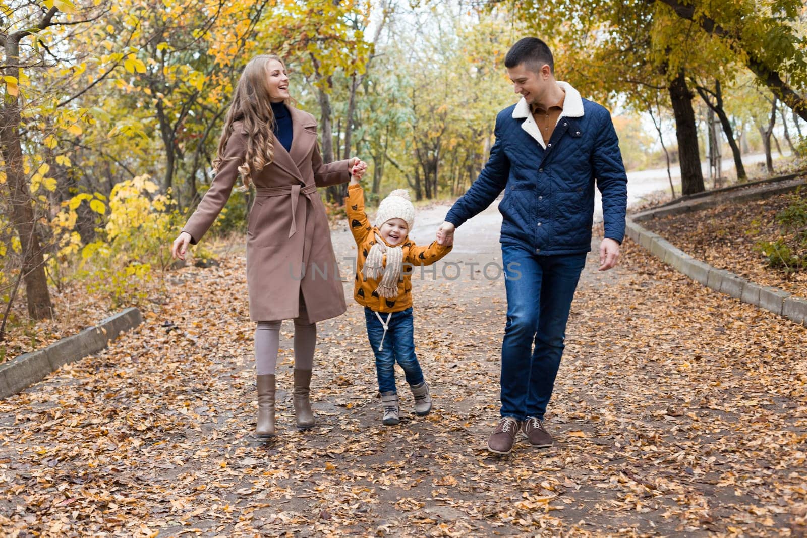 a family with a young son walk in the Park in autumn 1