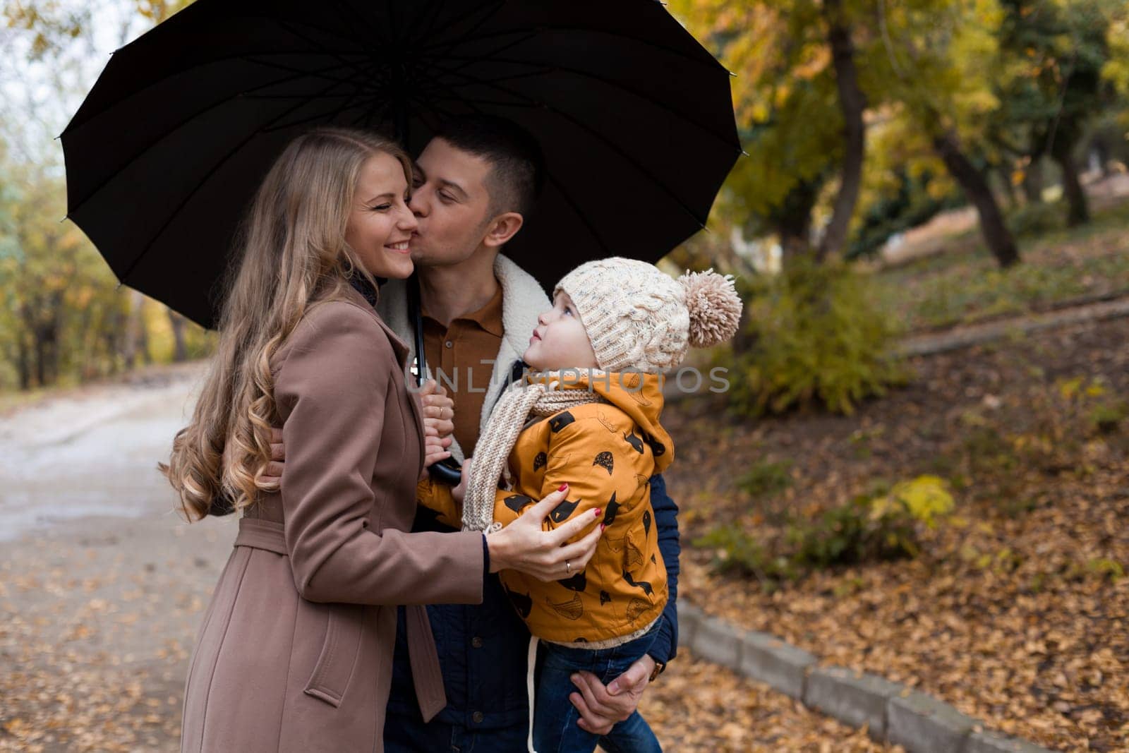 with his son's family in autumn in Park forest rain umbrella