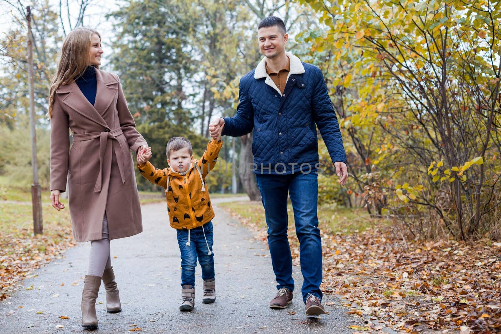 mom dad and a little boy walk in the Park by Simakov
