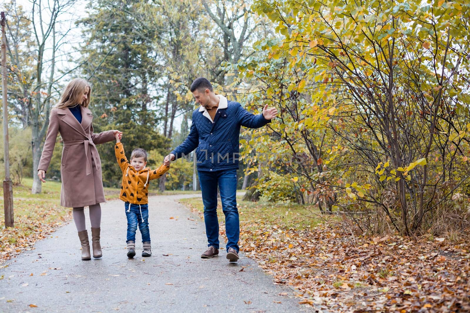 mom dad and a little boy walk in the Park 1