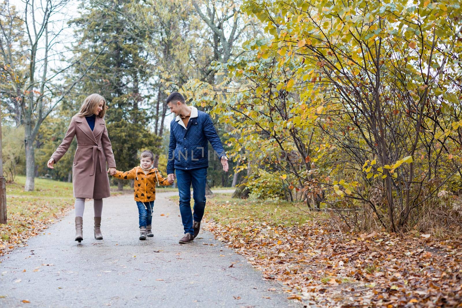 mom dad and a little boy walk in the Park 1