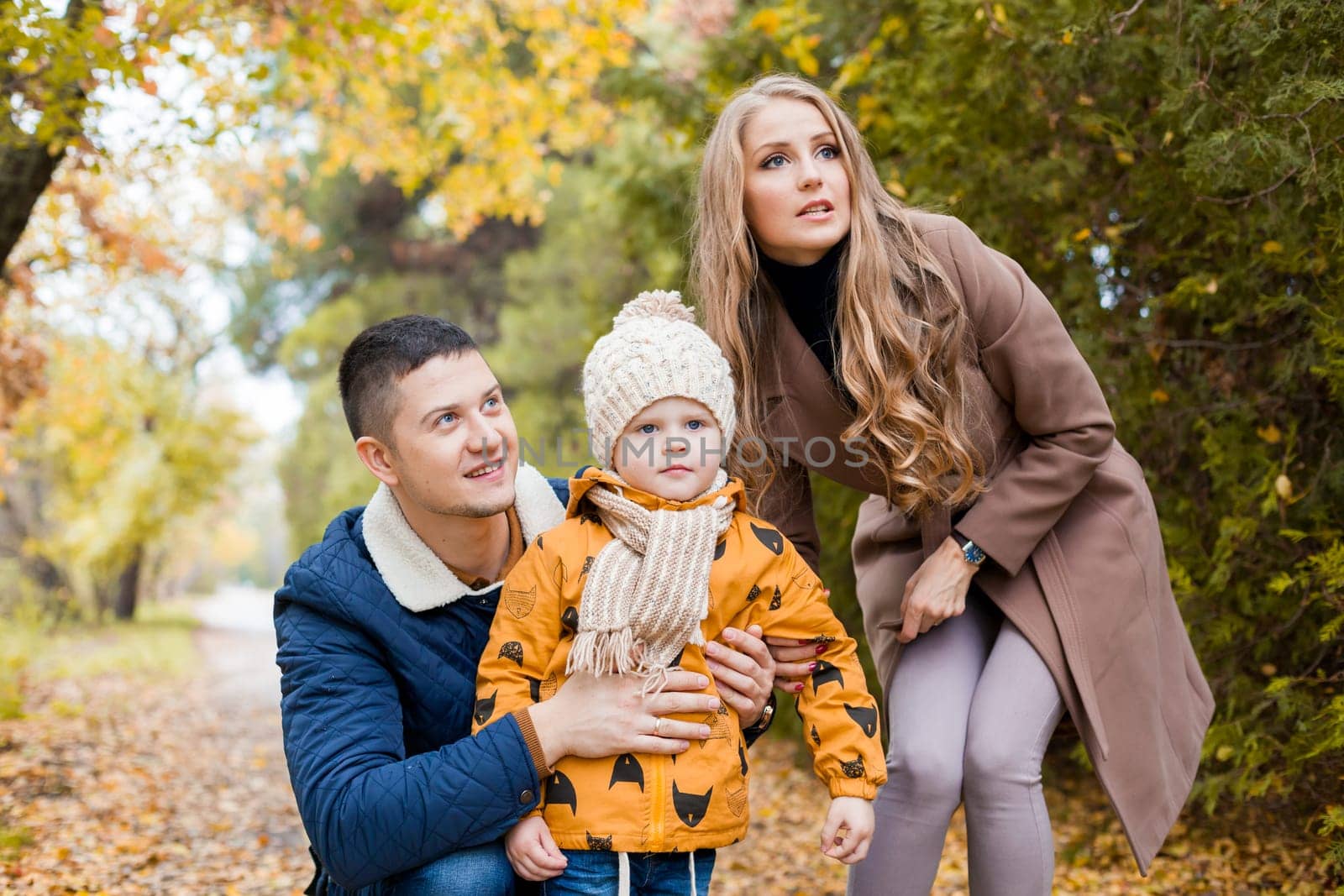 mom and dad and the little boy in the Park in autumn saw the birds