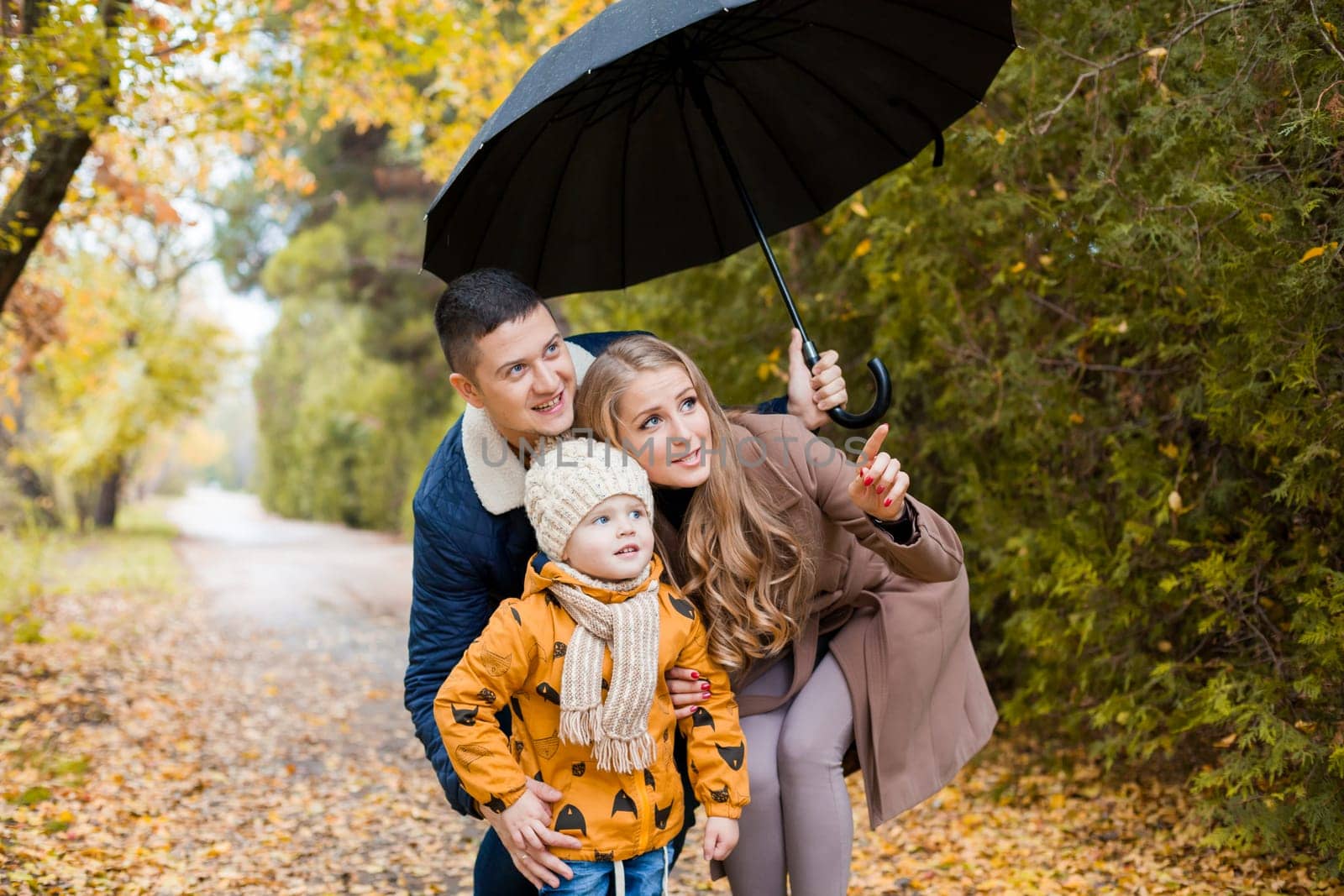 family walk in the autumn forest in the Park in the rain 1