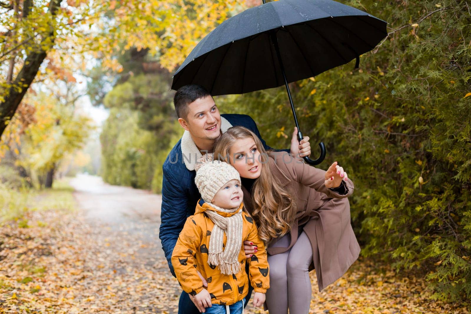 family walk in the autumn forest in the Park in the rain 1