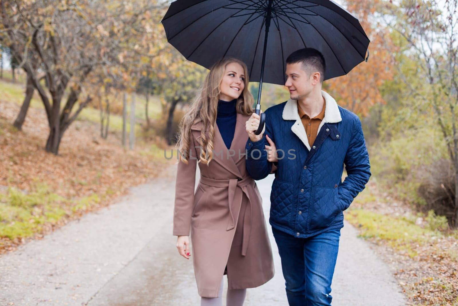 a guy with a girl in the Park of autumn rain umbrella 1