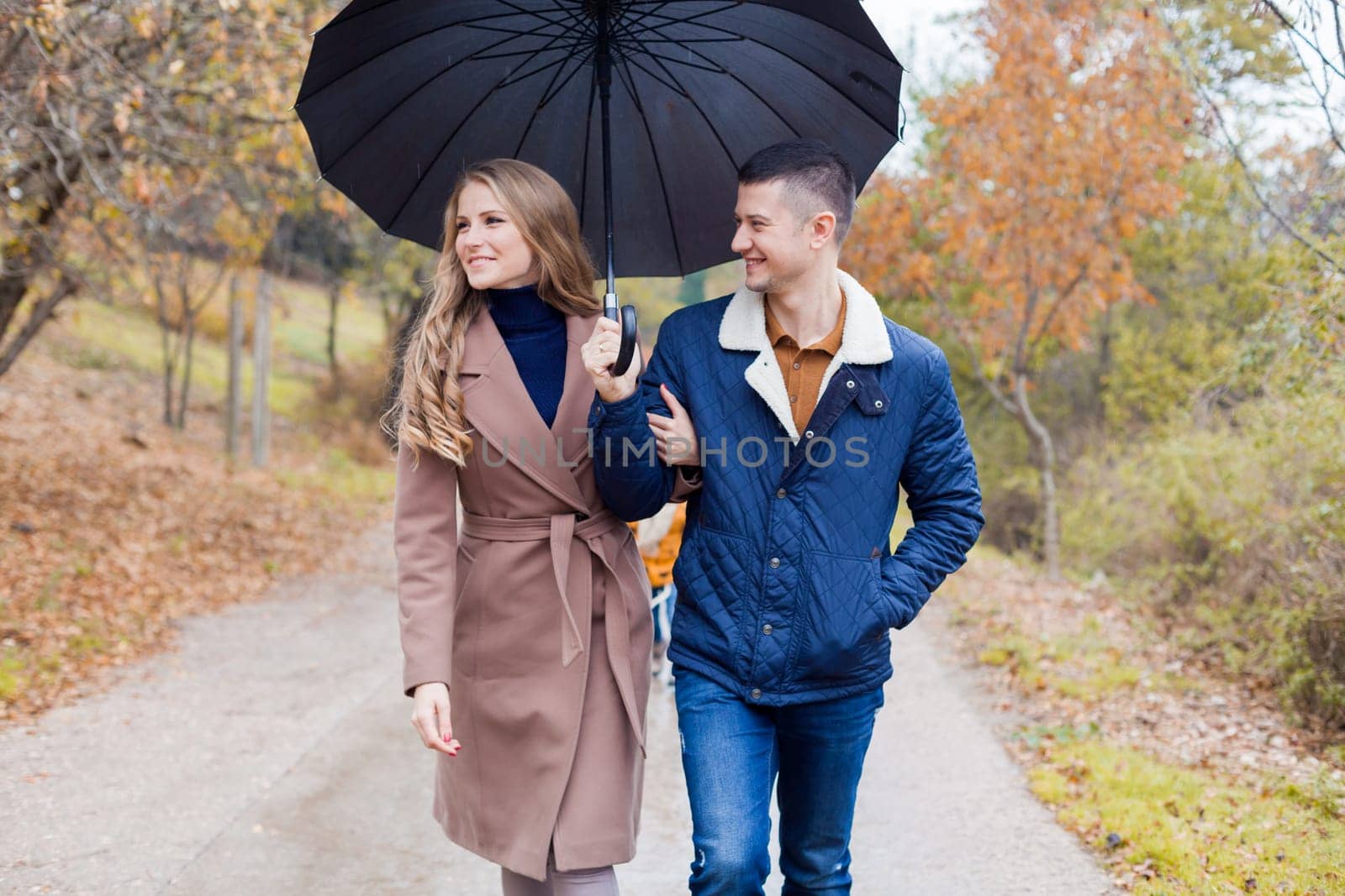 a guy with a girl in the Park of autumn rain umbrella 1