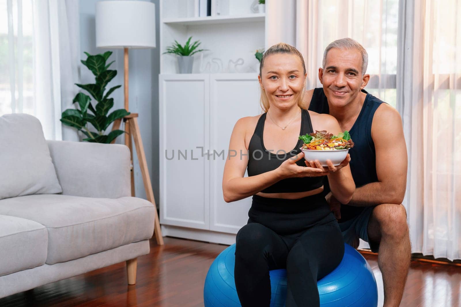 Healthy senior couple in sportswear with a bowl of fruit and vegetable. Healthy cuisine nutrition and vegan lifestyle for fitness body physique concept. Clout