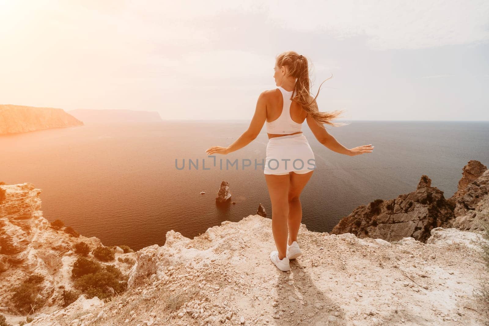 Woman travel sea. Young Happy woman posing on a beach over the sea on background of volcanic rocks, like in Iceland, sharing travel adventure journey by panophotograph