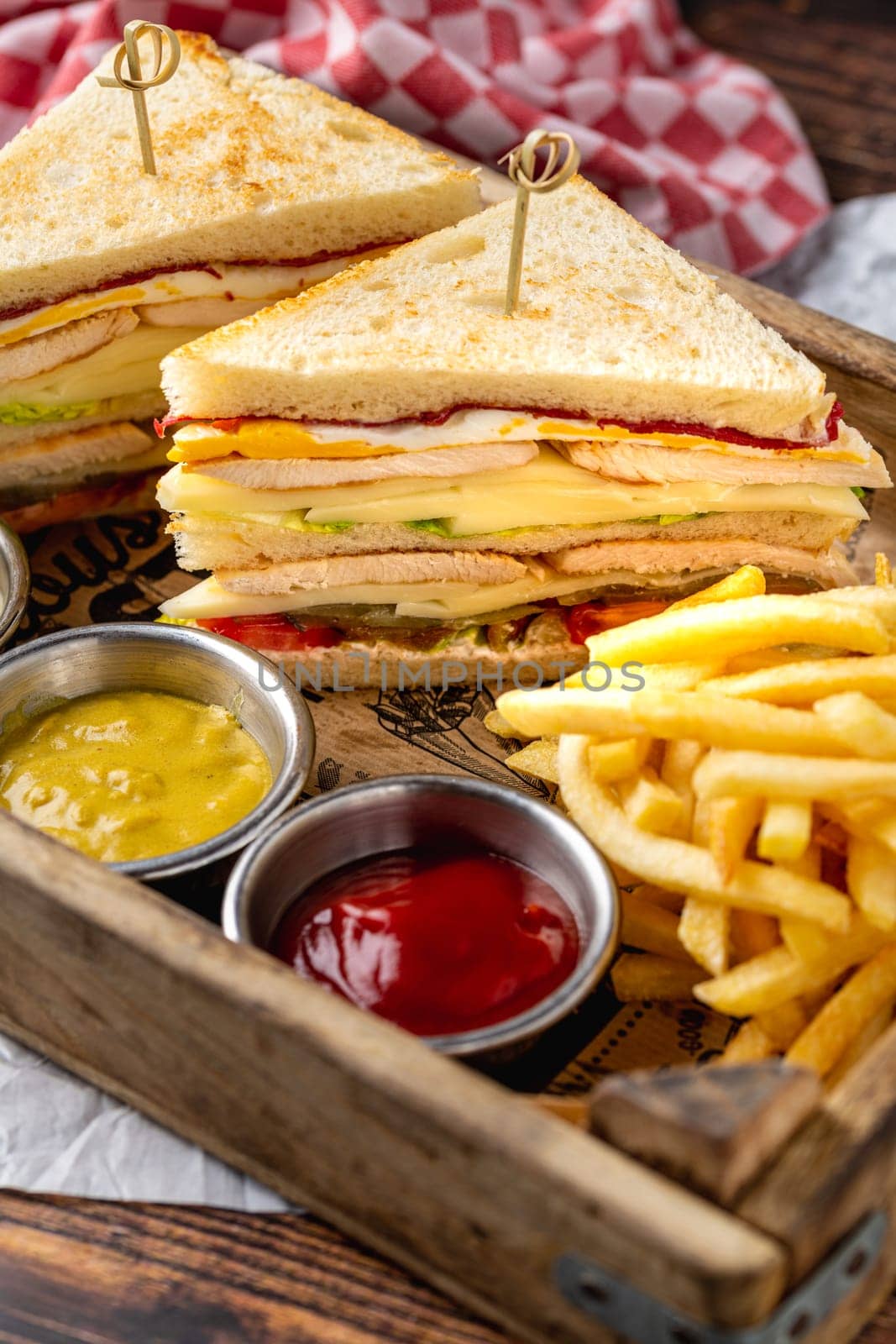 Chicken club sandwich with fries, ketchup, mustard and mayonnaise