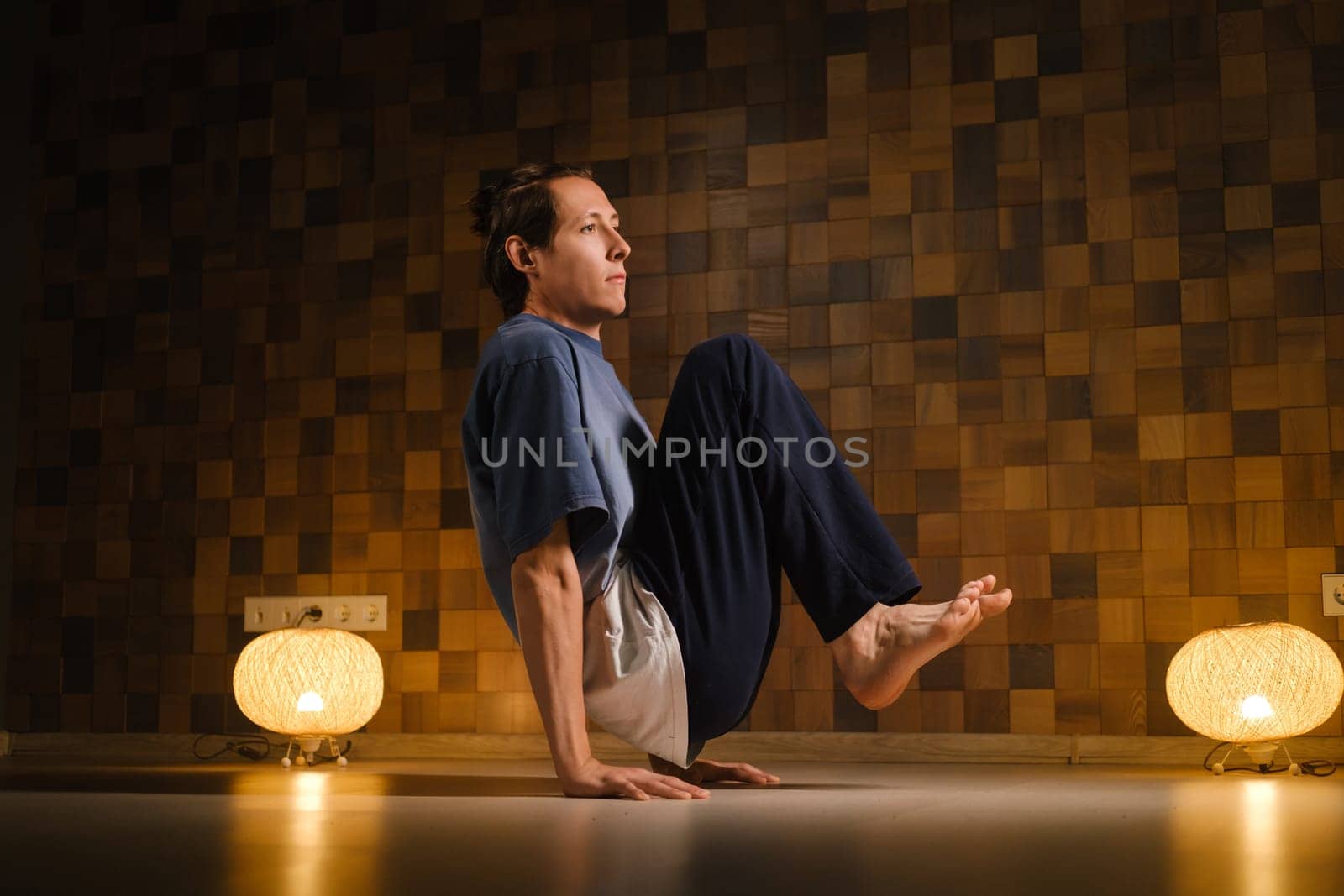 a man with a naked torso does yoga in the gym. the concept of a healthy lifestyle.