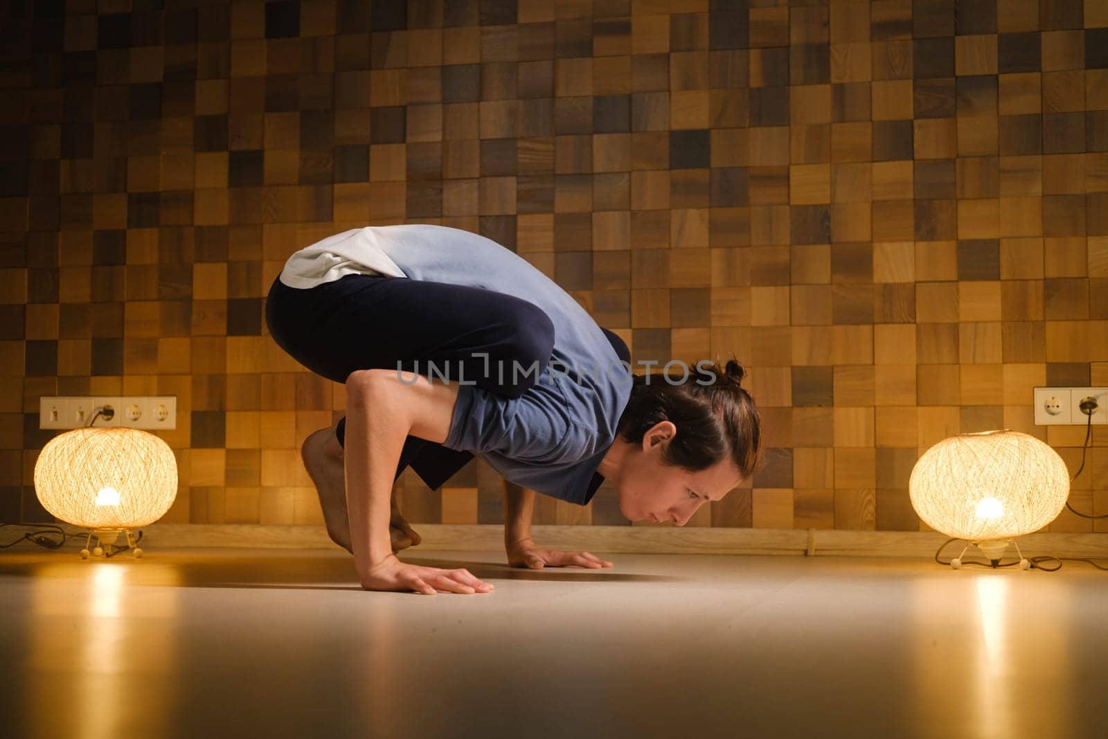 a man with a naked torso does yoga in the gym. the concept of a healthy lifestyle by Lobachad