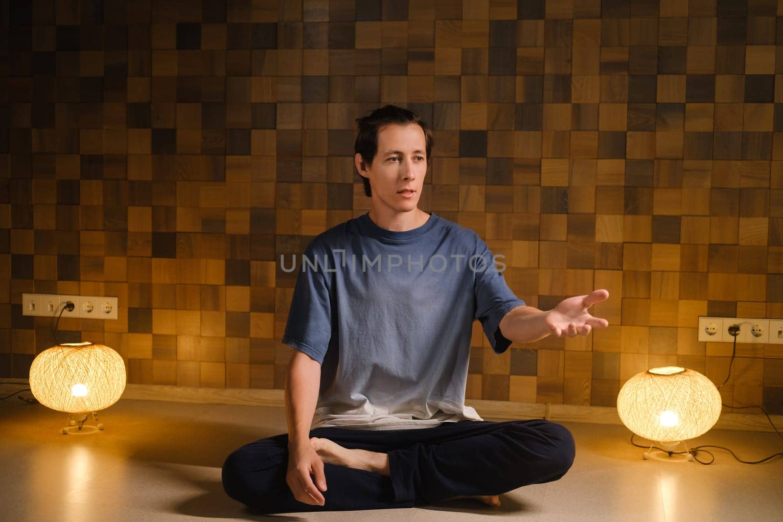 a man in a sports uniform does yoga in a fitness room. the concept of a healthy lifestyle by Lobachad