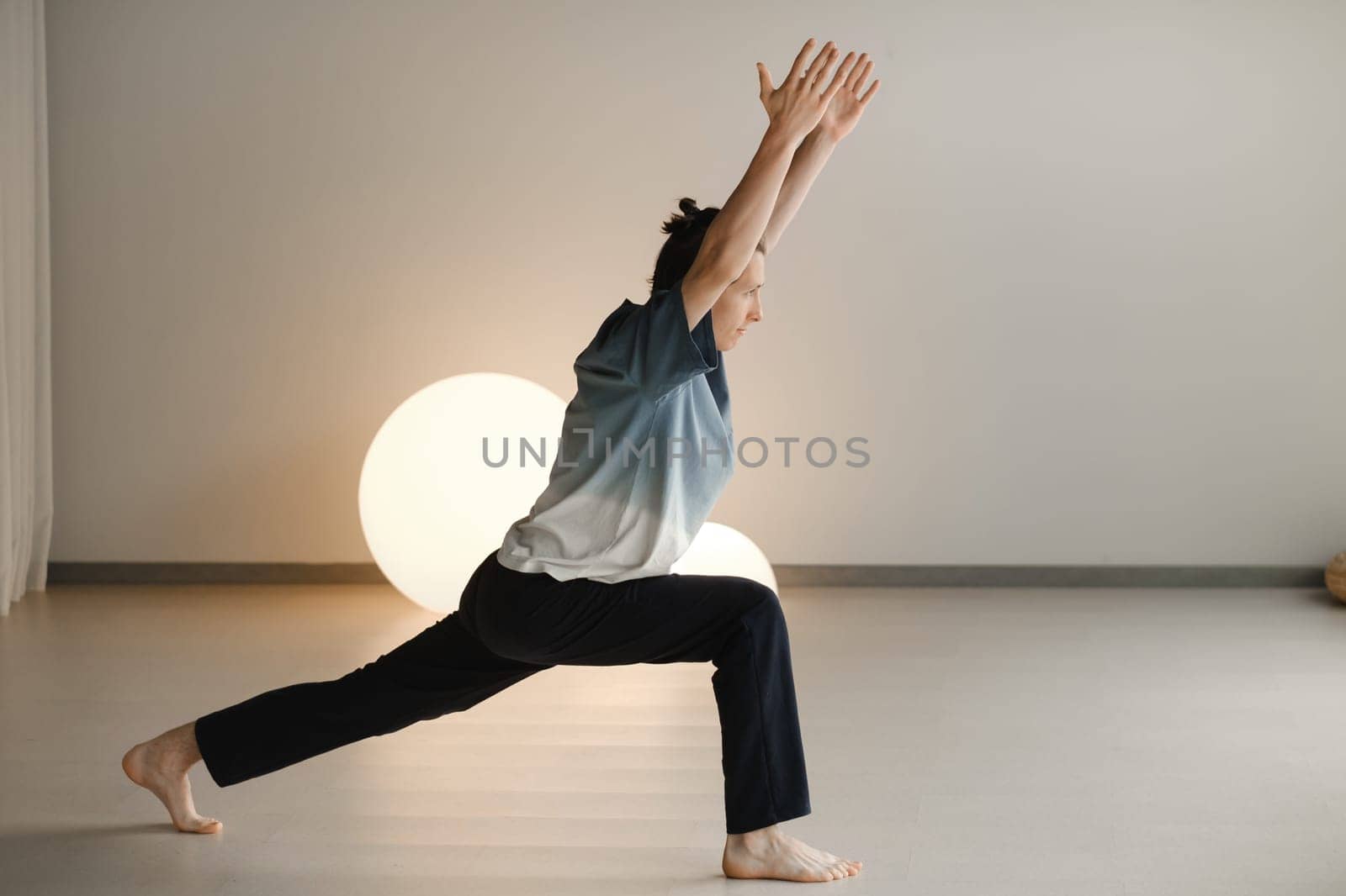 a man in a sports uniform does yoga in a fitness room. the concept of a healthy lifestyle by Lobachad