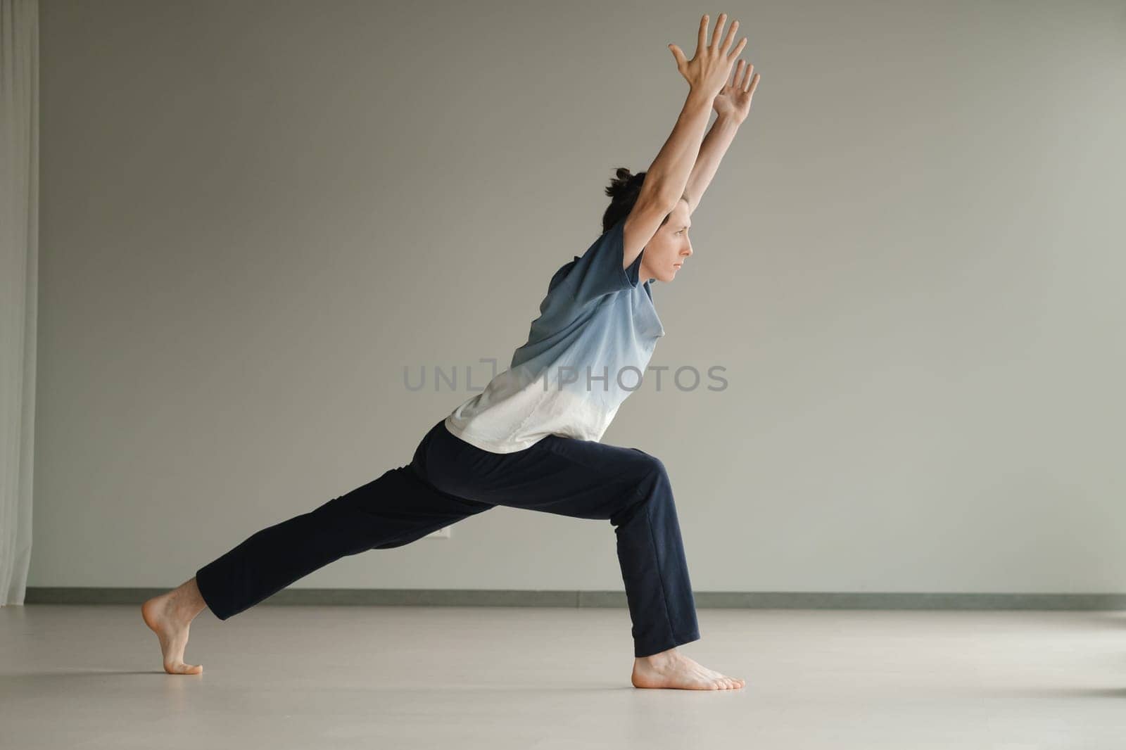 a man in a sports uniform does yoga in a fitness room. the concept of a healthy lifestyle by Lobachad