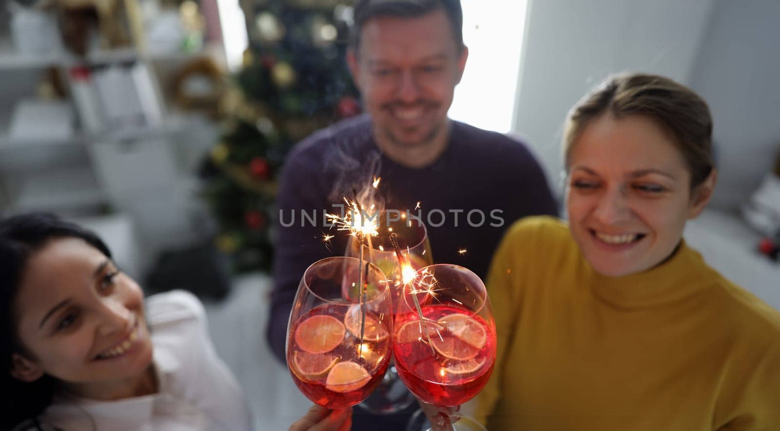 Cheerful happy people hold alcoholic cocktails with sparklers closeup by kuprevich